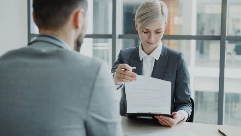 Nhân sự trao đổi hồ sơ tại văn phòng, minh họa đổi mã đơn vị BHXH, BHYT, BHTN năm 2026